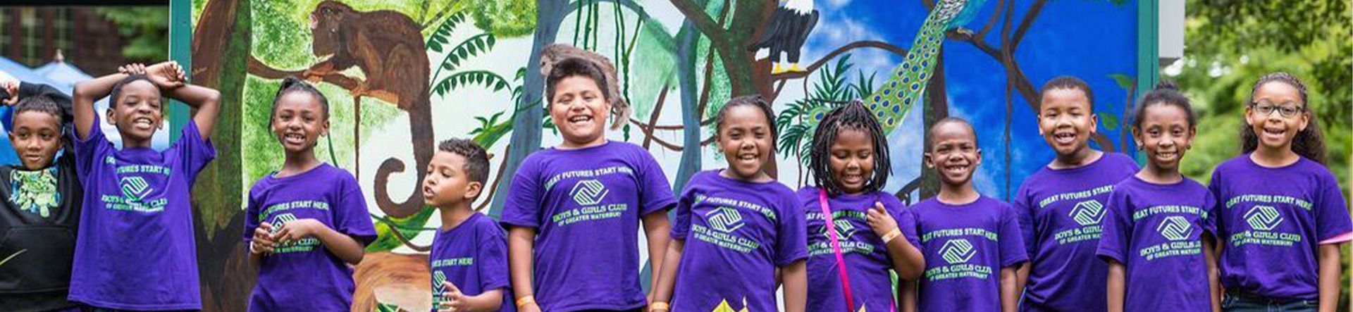 Group of kids wearing BGCGW tshirts standing in front of a mural